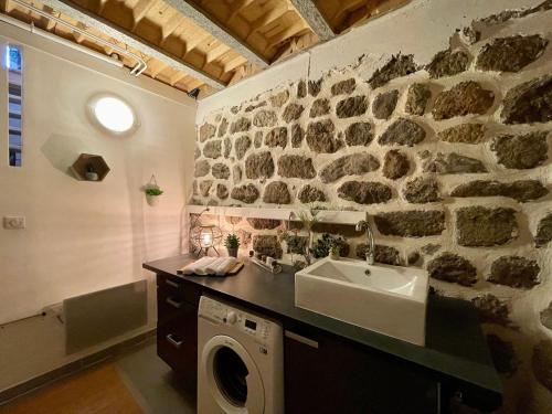a bathroom with a sink and a washing machine at Gîte Polignac, 3 pièces, 4 personnes - FR-1-582-58 in Polignac