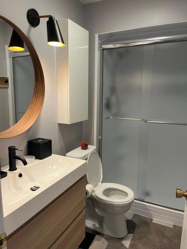 a bathroom with a white toilet and a shower at Newly Updated Modern, Spacious, and Cozy Condo- Right on the Lake! in Lake Geneva