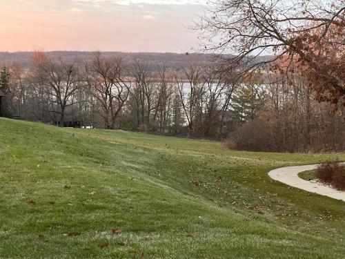 a grassy hill with a path next to a lake at Newly Updated Modern, Spacious, and Cozy Condo- Right on the Lake! in Lake Geneva