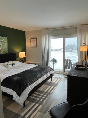 a bedroom with a large bed and a large window at Newly Updated Modern, Spacious, and Cozy Condo- Right on the Lake! in Lake Geneva