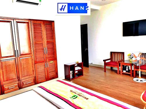 sala de estar con TV, mesa y sofá en HANZ Bao Long Hotel, en Ho Chi Minh