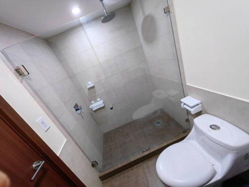 a bathroom with a toilet and a glass shower at 1001 Torres Los Yoses Apartamento con A/C y parqueo full equipado in San José