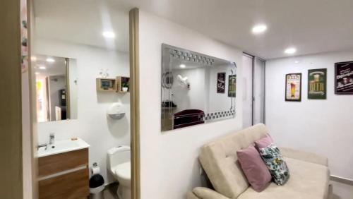 uma casa de banho com um sofá, um lavatório e um espelho. em Apartamento Amoblado de Una Habitación Doble em Ríohacha