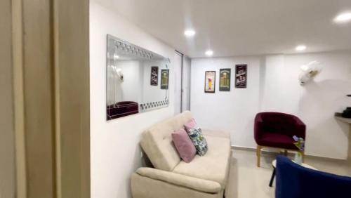uma sala de estar com um sofá e um espelho em Apartamento Amoblado de Una Habitación Doble em Ríohacha
