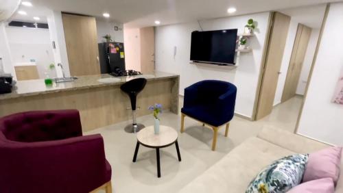 uma sala de estar com duas cadeiras e uma televisão em Apartamento Amoblado de Una Habitación Doble em Ríohacha