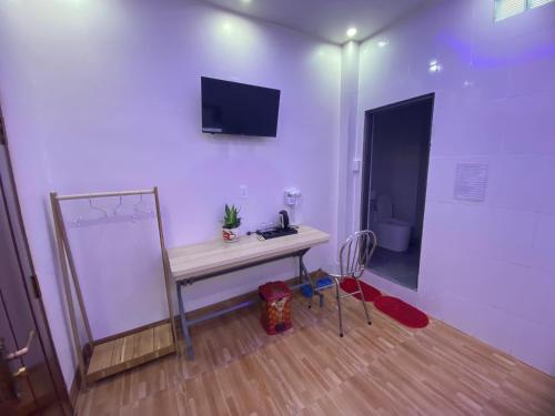 a room with a table and a mirror and a toilet at Khách sạn Trung Hiếu in áº¤p VÄ©nh ÃÃ´ng