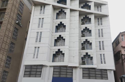 a white building with windows on the side of it at Super Collection O Hotel President in Guwahati