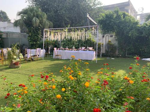 a table and chairs in a garden with flowers at Green Serene Abode in Meerut