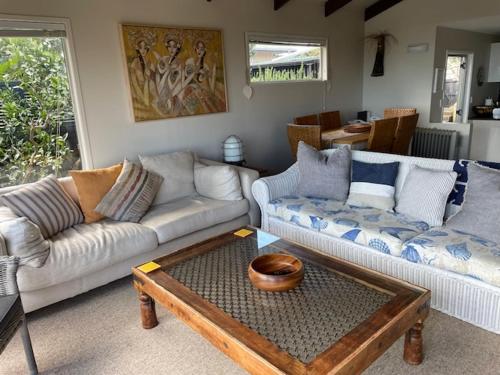 a living room with two couches and a coffee table at AHIPARA GOLDENSANDs in Ahipara