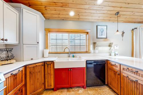 a kitchen with wooden cabinets and a red and white sink at Flagstaff Fantasy - Entire Property in Flagstaff