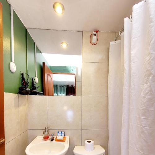 a bathroom with a sink and a toilet and a mirror at wayra house san blas in Cusco