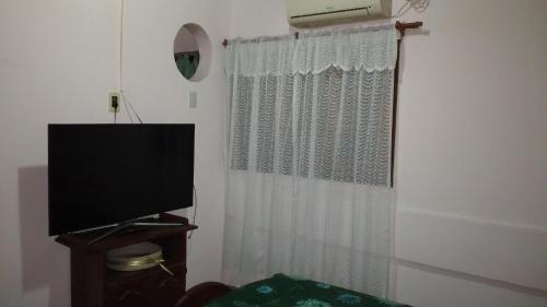 a living room with a television and a curtain at San Miguel in Formosa