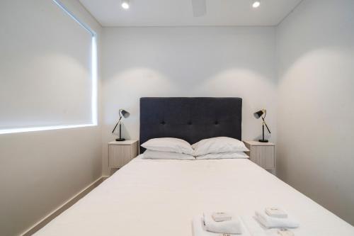 a bedroom with a large white bed with two lamps at EIGHT TWO NINE TWO V: BONDI BEACH in Sydney