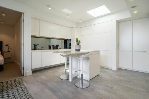 una cocina con armarios blancos y una mesa con una maceta. en EIGHT TWO NINE TWO V: BONDI BEACH, en Sídney