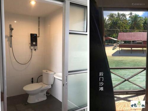 a bathroom with a toilet and a view of a pool at Mabul Backpackers in Pulau Mabul 