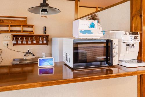 a microwave sitting on top of a kitchen counter at Funny Inn in Hakuba