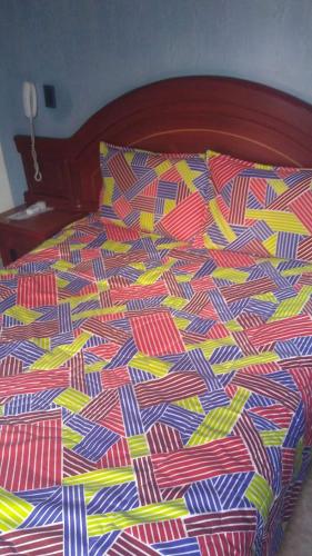 a bed with a colorful comforter on it at Hoe in Bogotá