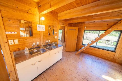 una cocina con 2 lavabos en una cabaña de madera en Tsushima Miuda Pension, en Tsushima