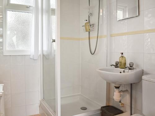 biała łazienka z umywalką i prysznicem w obiekcie Exmoor View w mieście Blue Anchor