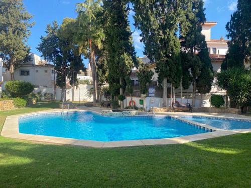 a swimming pool in the yard of a house at Ola Blanca Carihuela Apartamento in Torremolinos