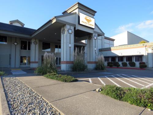 een vooraanzicht van een gebouw met een parkeerplaats bij Pacific Sunrise Inn & Suites in Ocean Shores