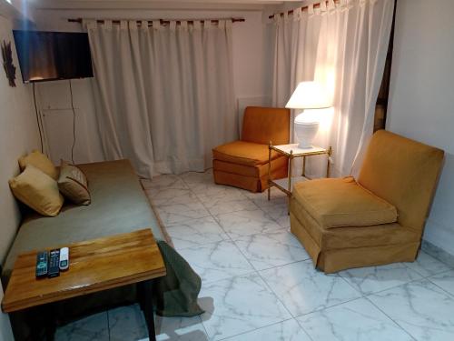 - un salon avec un canapé, des chaises et une table dans l'établissement Departamento dos ambientes Belgrano R, à Buenos Aires
