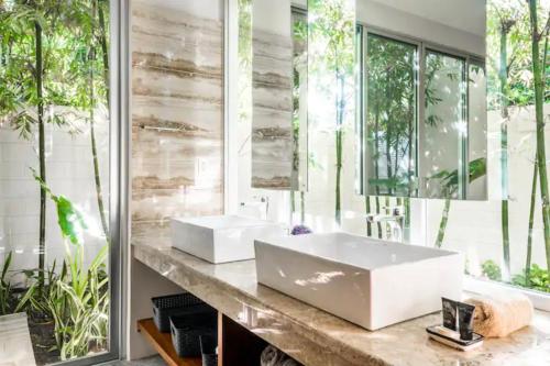 a bathroom with two sinks and a large mirror at Casa Cuatro Vientos in Tulum