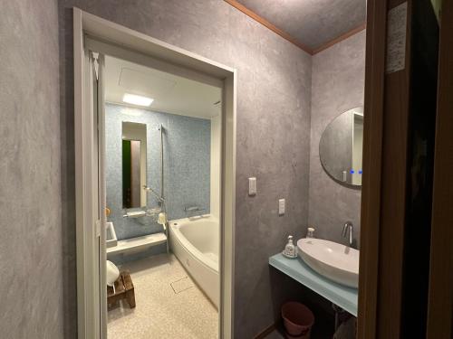 a bathroom with a tub and a sink and a bath tub at Numazu Ikyuuan 沼津一休庵 in Numazu