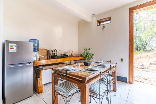 una cucina con tavolo in legno e frigorifero in acciaio inossidabile di Lodge Pochoco Refugio de Montaña a Santiago
