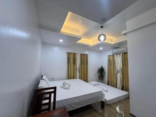 a room with a bed and a table and chairs at RICH-VANIA SUITES in General Luna