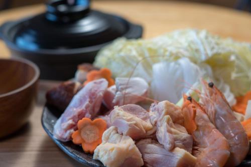 a plate of food with meat and vegetables on a table at Tsushima Miuda Pension in Tsushima