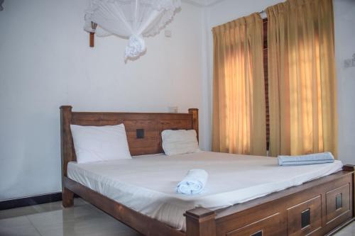 a bedroom with a large bed with a wooden headboard at Sea Zone Resort in Mirissa