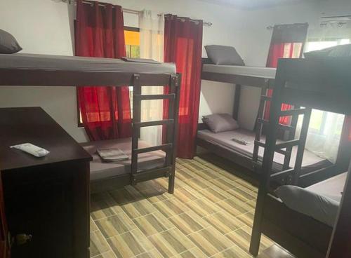 a dorm room with bunk beds with a desk and a table at Sky Hostel in Fortuna