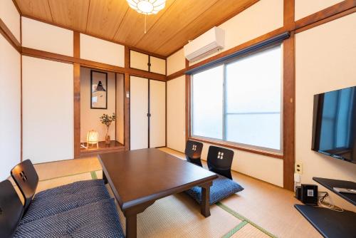 a dining room with a table and a television at GuestHouse　YOU&I平和島 in Tokyo
