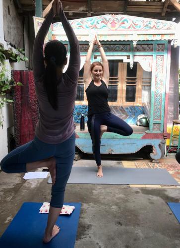 two women doing yoga in front of a truck at Rumah Kalpataru in Yogyakarta