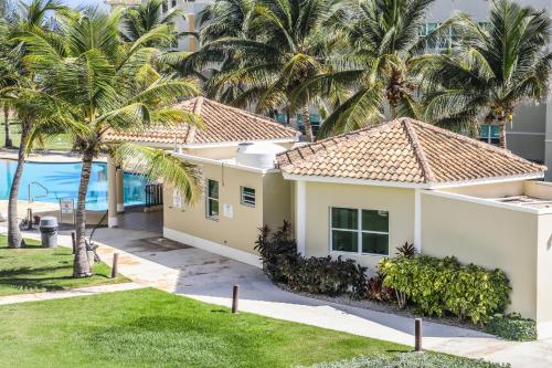 een huis met palmbomen voor een gebouw bij Paradise Beach Home @Jobos beach in Isabela