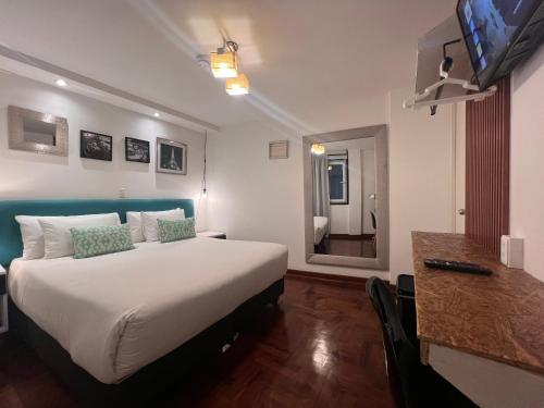 a hotel room with a large bed and a television at La Casa del Viajero in Lima