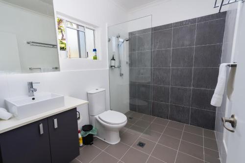 a bathroom with a toilet and a sink and a shower at Escape Life @ Port Douglas in Port Douglas