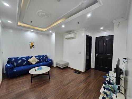 a living room with a blue couch and a table at The Peninsula Haiphong in Hai Phong