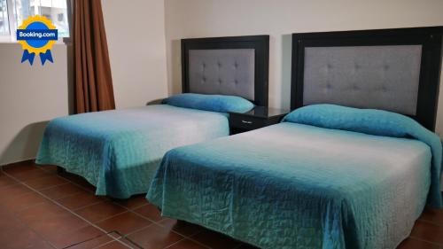 2 camas en una habitación de hotel con sábanas azules en Casa Rinconsito Miramar, en San Blas