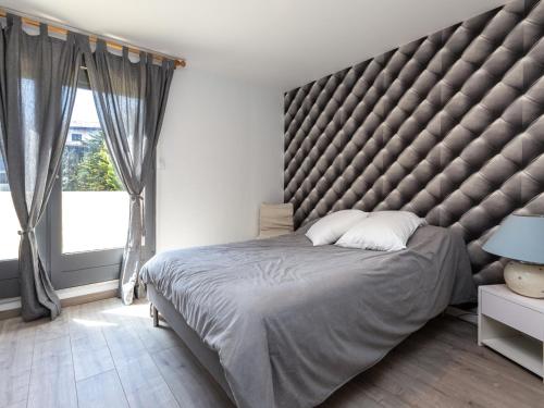 a large bed with a large padded headboard in a bedroom at Appartement Seignosse, 3 pièces, 4 personnes - FR-1-239-463 in Seignosse