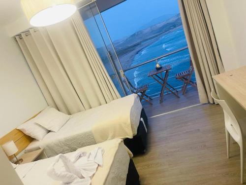 a room with two beds and a view of the ocean at Serenity Inn Los Chimus in Tortuga