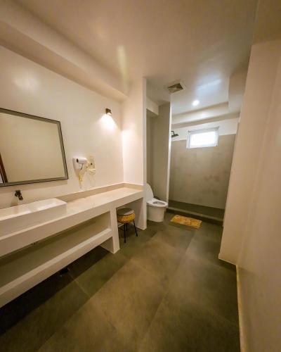 a bathroom with a sink and a toilet and a mirror at Bathala Resort in Panglao