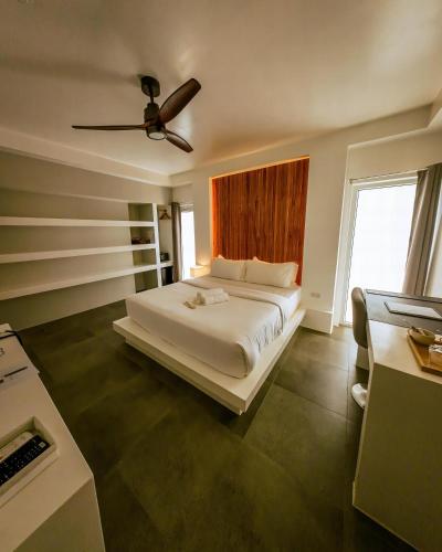 a bedroom with a bed with a ceiling fan at Bathala Resort in Panglao