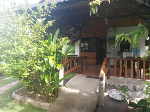 a porch of a house with a table and some plants at Gardenview Homestay Siargao in General Luna