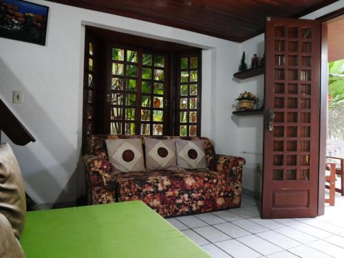 グラヴァターにあるChalé na Suíça Pernambucanaのリビングルーム(ソファ、緑のテーブル付)