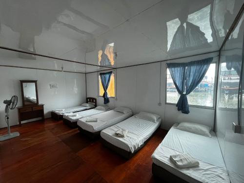 a room with four beds and a mirror at Mabul Backpackers in Pulau Mabul 