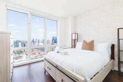 a bedroom with a white bed and a large window at Super Luxury Penthouse 3bd 3bath in Jersey City