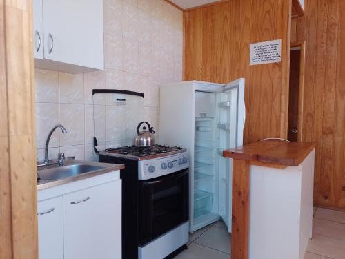 a small kitchen with a stove and a sink at Cabañas Marlen in Limache