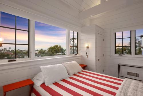 een witte slaapkamer met een rood en wit gestreept bed bij Coastal La Jolla Luxury - AC & Large Ocean View Patio! in San Diego